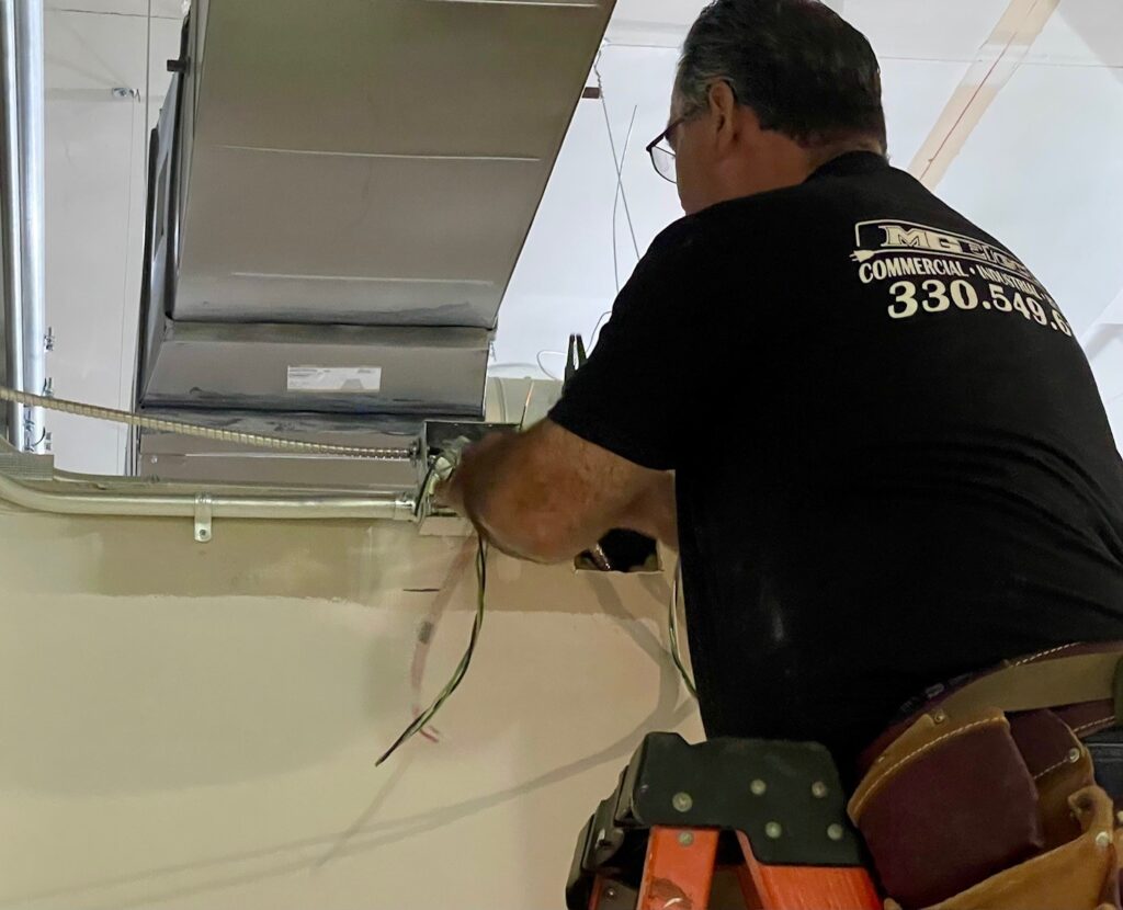Louis Ross, of MG Electric, pulling new wire into boxes for the building.