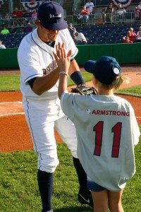 Heaven Doss of Big Brothers Big Sisters celebrates with Scrapper Josh McAdams after throwing out the ceremonial first pitch on behalf of NECA-IBEW Electricians.