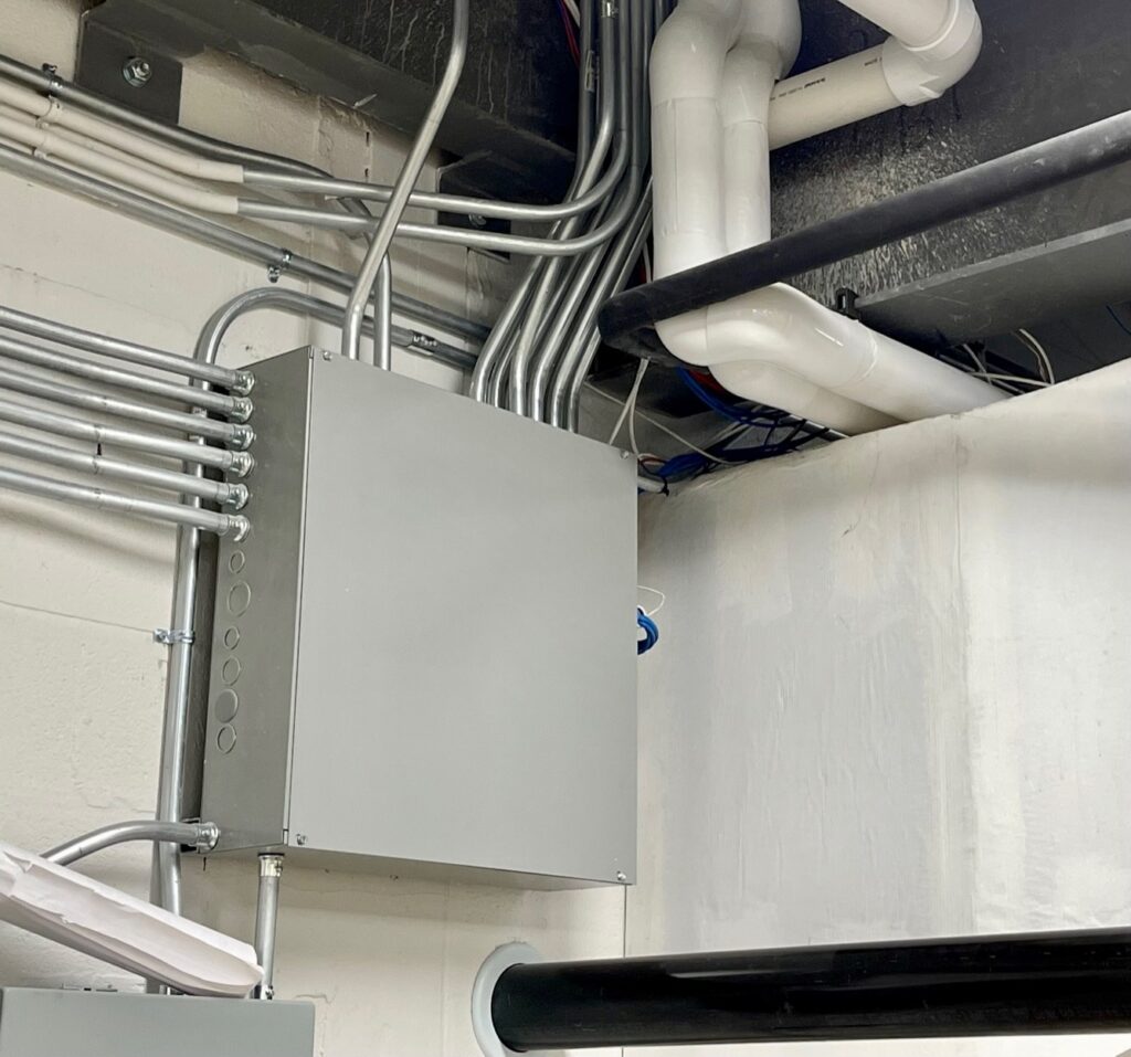 Lines from wall panel run to electrical box in basement