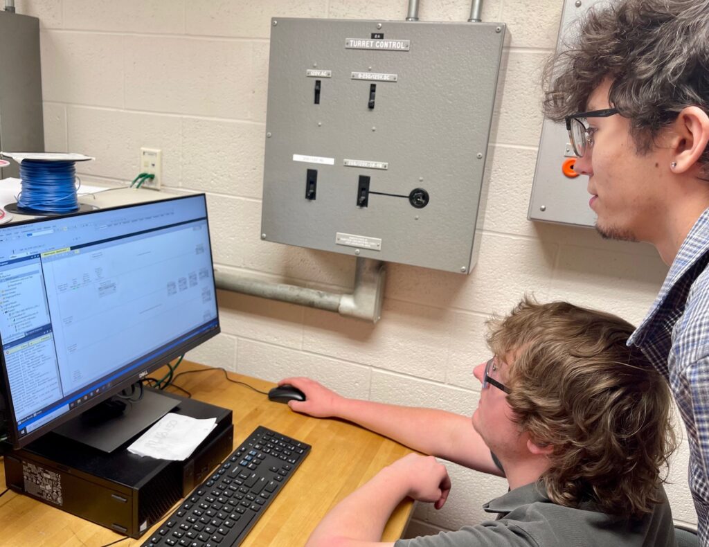 Waldon and Zouck looking at PLC programming. 