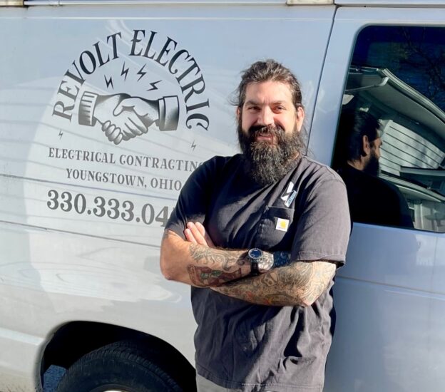 Sam Decesare, owner of Revolt Electric, outside his work van.